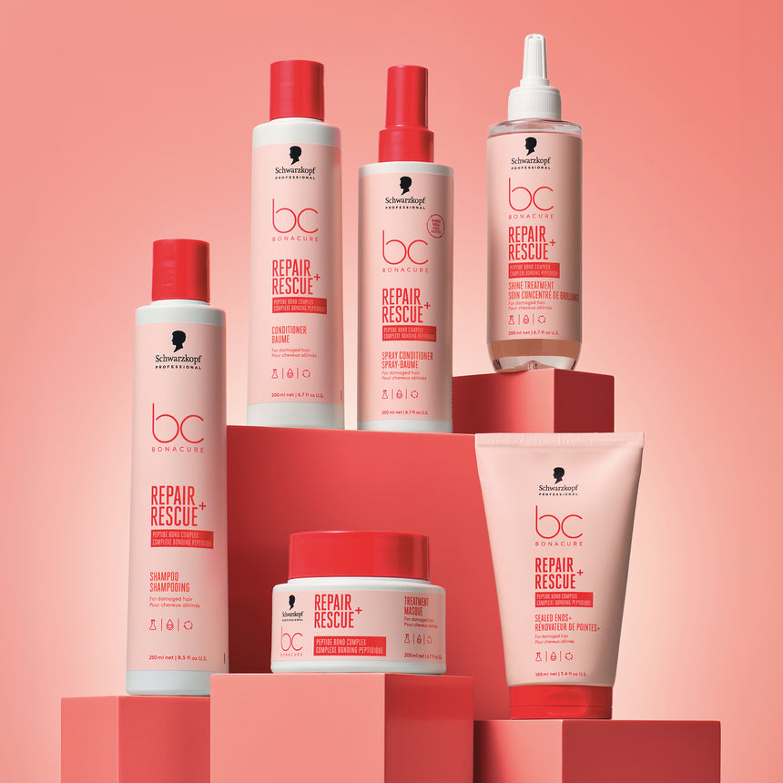 Schwarzkopf Professional Repair Rescue products displayed on red pillars with a light red radiant backdrop.