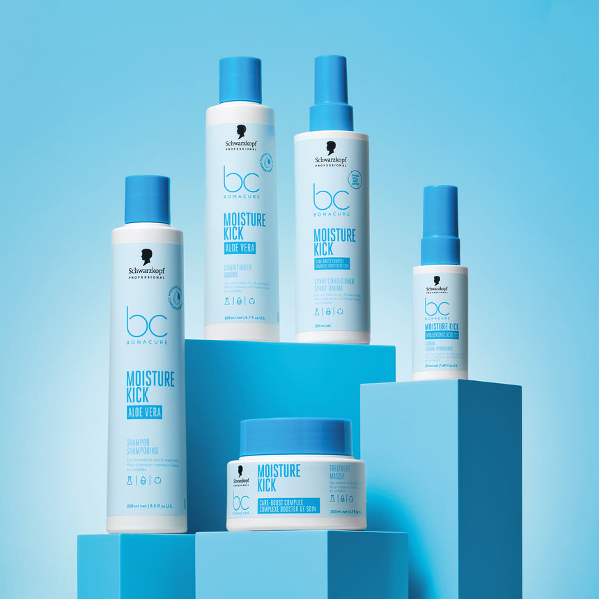 Schwarzkopf Professional Moisture Kick products presented on blue pillars with a light blue radiant backdrop.
