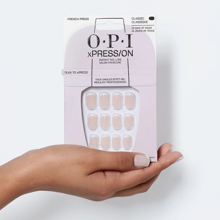 Hand holding OPI False Nails against a clean white studio setting.