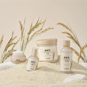 SkinFood Rice skincare collection displayed on a bed of rice with rice stalks against a soft neutral background.