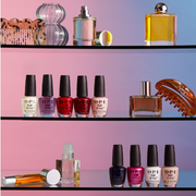 A variety of OPI products displayed against a pink and blue ombre backdrop.