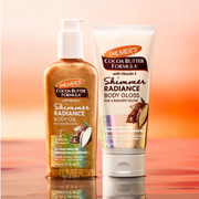 Palmer's Shimmer Radiance Body Oil and Shimmer Radiance Body Gloss are presented in a sunset-inspired blurred backdrop.
