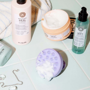 Maria Nila Head & Hair Heal Shampoo, True Soft Argan Oil, Head & Hair Heal Hair Masque displayed on pale tiles with a towel, jewellery and creamy product textures.