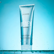 Color Wow Money Laundering Conditioner standing against a bright blue background with water droplets.