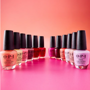 A variety of OPI nail polishes displayed against a vibrant pink and orange ombre background.