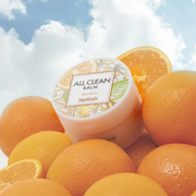 Heimish All Clean Balm displayed with mandarins against a sky-inspired backdrop.