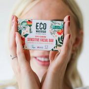Woman holding Little Soap Company Sensitive Facial Bar against a white studio backdrop.