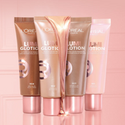 A variety of L'oreal Paris Lumi Glotion products displayed on a light pink backdrop.