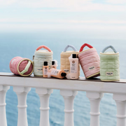Maria Nila Haircare Beauty Bags displayed in pastel quilted packaging on a balcony overlooking the sea.