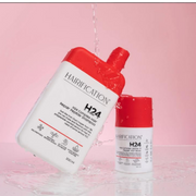 Hairification H24 Complex Hair Repair Peptide Shampoo and Hairification H24 Complex Leave-In Repair Hair Mask displayed with water-inspired elements against a pink backdrop.