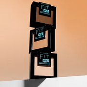 Multiple shades of the Maybelline Fit Me Matte + Poreless Pressed Powder displayed against a radiant light orange backdrop.