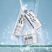 Color Wow haircare products splashing through water against a fresh light blue background.
