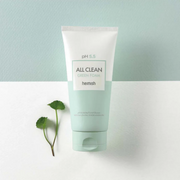 Heimish All Clean Green Foam facial cleanser tube displayed on a white surface with green leaves against a pale mint background.