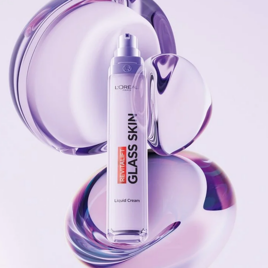 L'oreal Paris Revitalift Glass Skin Liquid Cream displayed against iridescent bubbles on a white display.