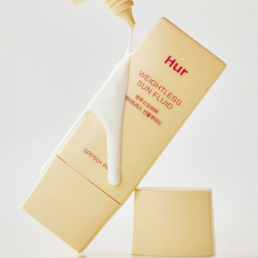 House Of Hur Weightless Sun Fluid displayed with glossy product drips against a neutral backdrop.