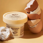 SkinFood Egg White Pore Mask displayed with egg shells against a beige backdrop.