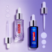 L’Oréal Paris Revitalift serums with glass droppers and product droplets displayed against a purple gradient background.