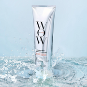 Color Wow Color Security Shampoo standing in splashing water against a soft blue background.