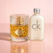Kilian Angels’ Share and Calvin Klein One fragrances displayed on a soft pink background.