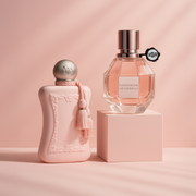 Parfums de Marly Delina and Viktor & Rolf Flowerbomb fragrances displayed on a soft pink background.
