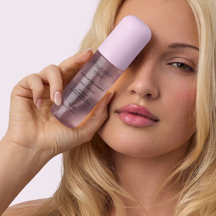 Woman holding Gem Vanilla Macadamia Body and Hair Fragrance Mist against a white studio backdrop.