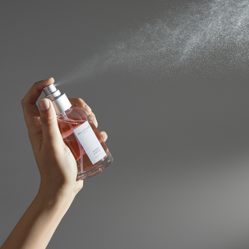 Millefiori Ambra & Rosa home fragrance spray being misted against a soft grey backdrop.