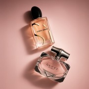 Giorgio Armani Sì and Gucci Bamboo women’s fragrances displayed on a soft blush pink background.